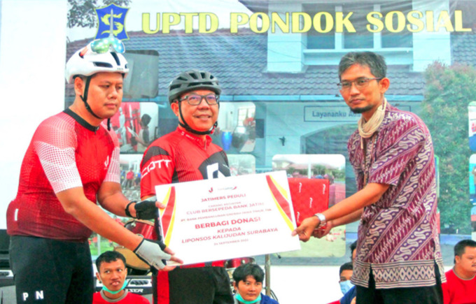 BERBAGI DONASI:  Direktur Konsumer Ritel dan Usaha Syariah, R Arief Wicaksono (tengah) didampingi Ketua Pengurus Cabang Kegiatan Bersepeda Bank Jatim Club, Bondan Seno Aji (kiri) menyerahkan secara simbolis bantuan kepada UPTD Liponsos Kalijudan yang dite