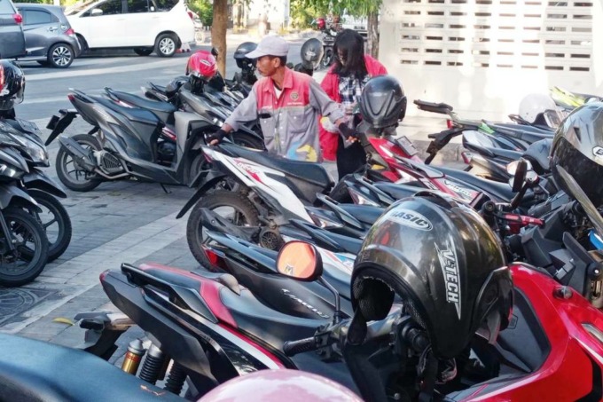 DISIPLIN: Juru parkir (jukir) mengatur kendaraan bermotor di Jalan Jimerto, Surabaya, Selasa (27/9).(SURYANTO/RADAR SURABAYA)