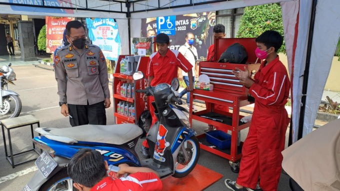 AKP Budi Junaedi S.Pd, Kepala Primkoppol Resta Malang saat mengecek penggantian oli gratis di booth Pertamina Lubricant. (ISTIMEWA)