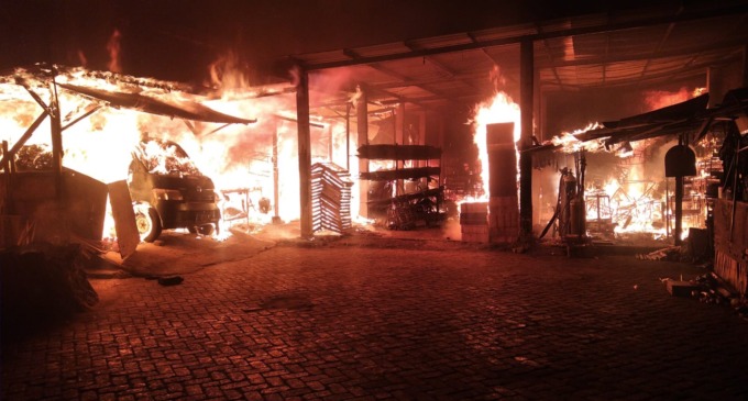 MEMBARA: Petugas DPKP berusaha memadamkan api yang menghanguskan gudang tripleks di Jalan Banjarsugihan, Surabaya. (IST)