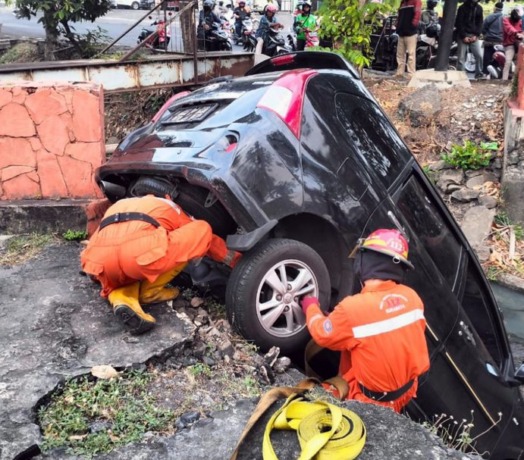 EVAKUASI: Petugas mengevakuasi mobil milik Pandu Wicaksono yang tercebur sungai di Jalan Jemursari, Kamis (8/9). (IST)
