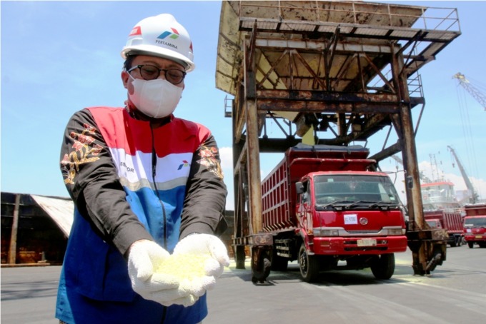 PERDANA: Sales Area Manager Petrohemical Jatimbalinus, Hardika Adiyagsa menunjukkan produk petrokimia berupa sulfur granule yang siap dikirim ke pelanggan. (ABDULLAH MUNIR/RADAR SURABAYA)