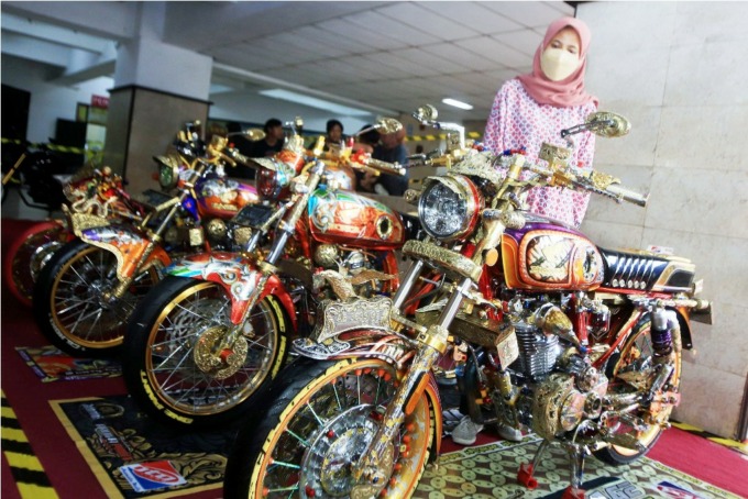 ADA MOTIF BATIK HINGGA WAYANG: Pengunjung mengamati motor CB klasik yang telah dimodifikasi, dalam kontes modifikasi motor di salah satu kampus swasta di Surabaya Timur. (ANDY SATRIA/RADAR SURABAYA)