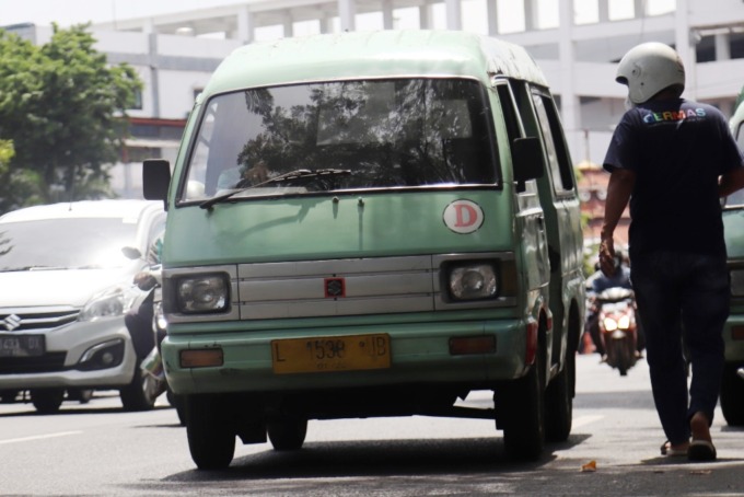 PENGUMPAN: Mobil angkot melintas di jalan Raya Wonokromo, Surabaya. (SURYANTO/RADAR SURABAYA)