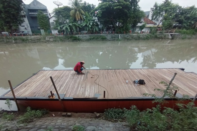Pekerja menyelesaikan pengerjaan dermaga di aliran Sungai Kalimas, Peneleh, Surabaya, Selasa (27/12). (SURYANTO/RADAR SURABAYA)