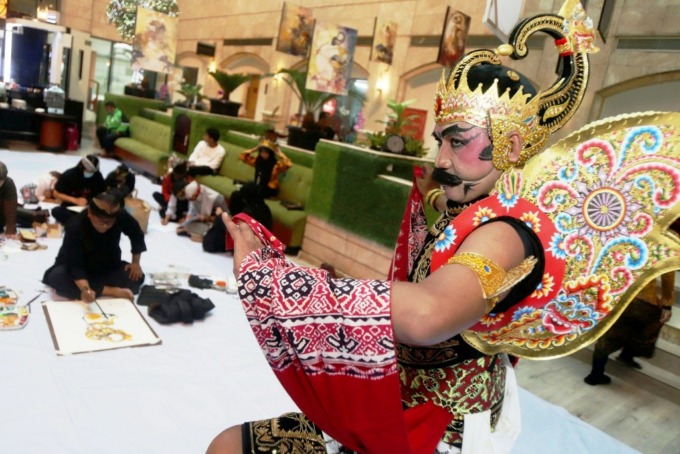 TOKOH PEWAYANGAN: Seniman lukis mengikuti melukis tokoh pewayangan Gatot Kaca secara on the spot di salah satu hotel di pusat kota Surabaya, Rabu (30/11). (ANDY SATRIA/RADAR SURABAYA)