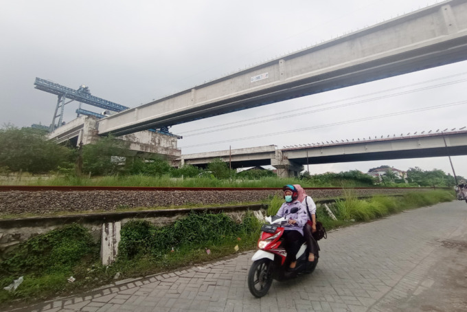 MASIH SEPI: Warga melintas tak jauh dari JLLB di kawasan Sememi, Surabaya.  (SURYANTO/RADAR SURABAYA)