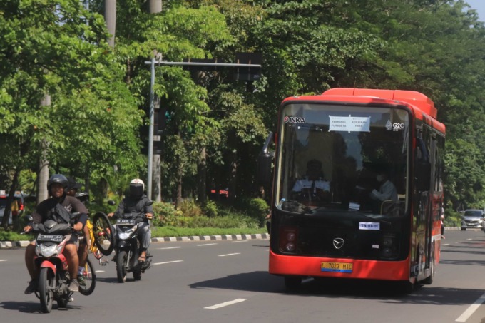RAMAH LINGKUNGAN: Armada bus listrik eks G20 melintas di Jalan Dr Ir Soekarno, Surabaya, Minggu (18/12). (SURYANTO/RADAR SURABAYA)