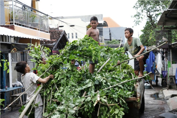 KEGIATAN POSITIF: Warga, termasuk para remaja bahu membahu membersihkan lingkungannya saat kegiatan kerja bakti Surabaya Bergerak di salah satu pemukiman di Surabaya, Minggu (4/12). (SURYANTO/RADAR SURABAYA)