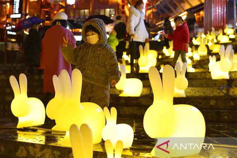 Seorang anak berpose di antara lampion-lampion berbentuk kelinci di wilayah Xuan
