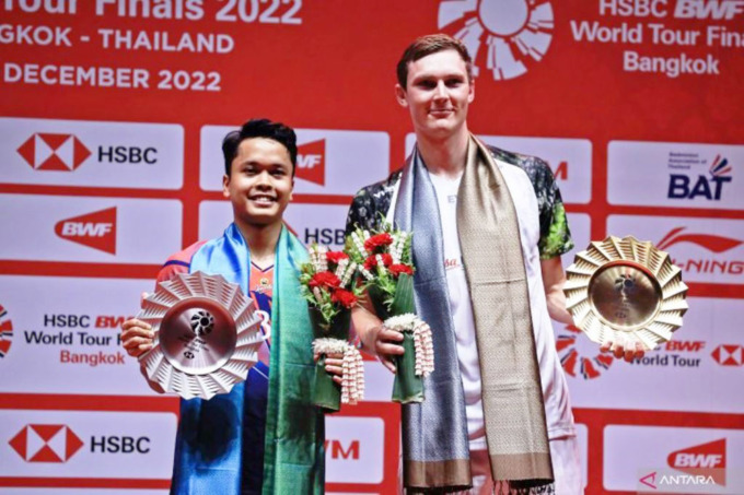 Pebulutangkis tunggal putra Indonesia Anthony Sinisuka Ginting (kiri) berfoto dengan lawannya asal Denmark Viktor Axelsen usai pertandingan babak final BWF World Tour Finals 2022 di Nimibutr Arena, Bangkok, Thailand, Minggu (11/12/2022). ANTARA FOTO/Hando