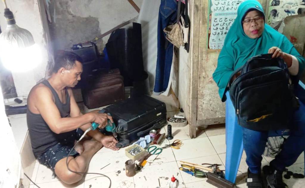 SUDAH TERSOHOR: Mujarwati dan suaminya, salah satu yang menekuni usaha reparasi tas dan koper di kawasan Gemblongan. (MUS PURMADANI/RADAR SURABAYA)