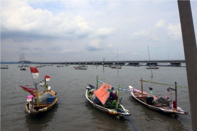 ANTISIPASI: Sejumlah perahu nelayan berlabuh di kawasan Jembatan Suramadu, Surabaya. (ANDY SATRIA/RADAR SURABAYA)