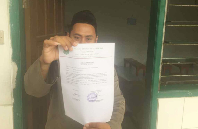 SANKSI TEGAS: Pengurus yayasan menunjukkan surat pemecatan terhadap AR, oknum guru yang diduga mencabuli murid. (ISTIMEWA)