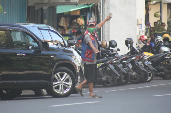 HARUS TERTIB: Juru parkir mengatur mobil di Jalan Baliwerti. Surabaya. (SURYANTO/RADAR SURABAYA)