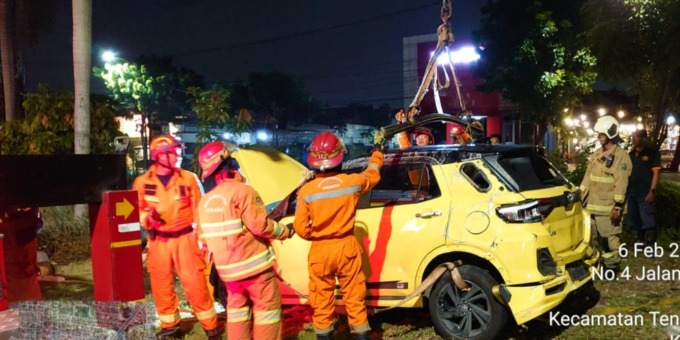 TERBALIK: Petugas mengevakuasi mobil yang mengalami kecelakaan tunggal di Jalan Jemursari 260, Surabaya. (IST)