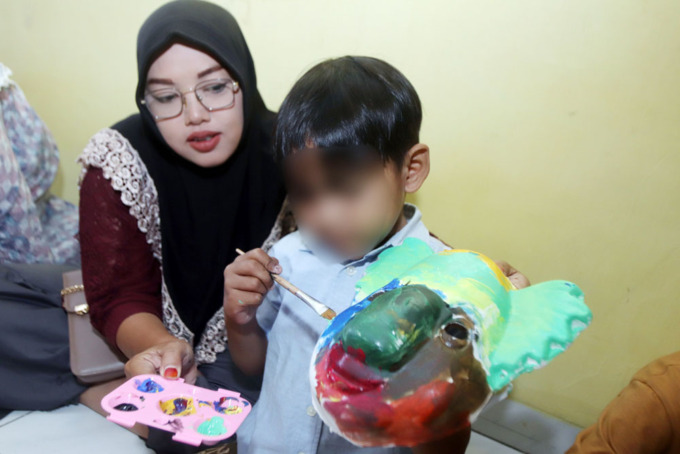 DUKUNGAN EMOSIONAL: Sejumlah Anak dengan HIV Aids (ADHA) mengikuti kegiatan melukis topeng bersama di kawasan Baratajaya, Kamis (16/2). (ANDY SATRIA/RADAR SURABAYA)