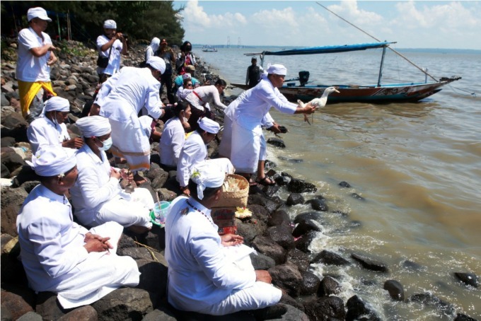 LARUNG SESAJI: Sejumlah petinggi umat Hindu melakukan upacara larung sesaji di Pantai Kenjeran Surabaya, Minggu (19/3). (ANDY SATRIA/RADAR SURABAYA)