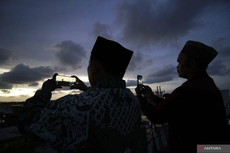 Tim rukyatul hilal dari Nahdlatul Ulama (NU) Kota Surabaya merekam menggunakan ponsel saat mengamati posisi bulan (hilal) di atas Masjid Al-Mabrur, Nambangan, Surabaya, Jawa Timur, Minggu (1/5/2022). Dalam pengamatan tersebut tim gagal melihat bulan yang