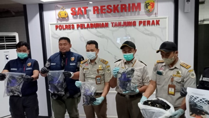 MATI: Kasatreskrim Polres Pelabuhan Tanjung Perak AKP Arief Ryzki Wicaksana (dua dari kiri) bersama BBKP Surabaya menunjukkan burung gagak hitam yang mati. (Guntur Irianto/Radar Surabaya)