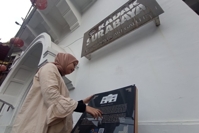 REKREASI DAN EDUKASI: Warga melihat papan cerita tentang bangunan cagar budaya di Jalan Kembang Jepun, Rabu (29/3).  (SURYANTO/RADAR SURABAYA)