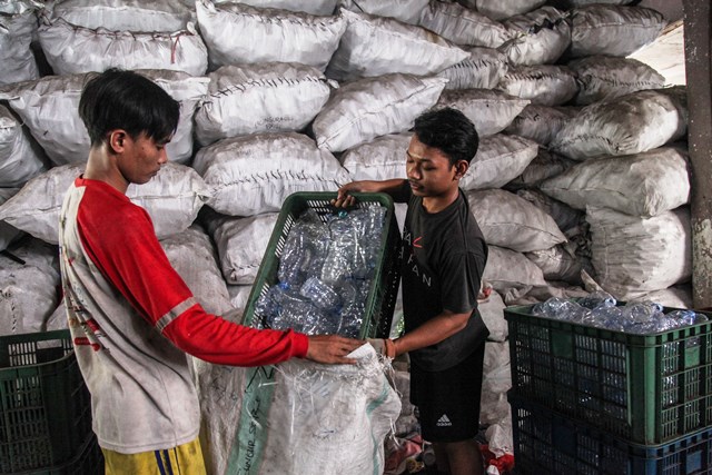 Pekerja memilah sampah botol plastik yang dikumpulkan di rumah kompos Rungkut, Surabaya,  (DOK. RADAR SURABAYA)