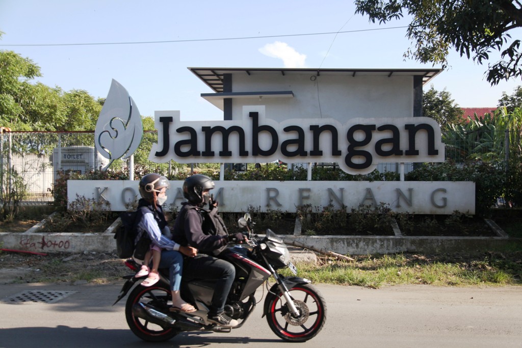 DIPERBAIKI: Pengendara kendaraan bermotor melintas tak jauh dari Kolam Renang Jambangan di Surabaya. (SURYANTO/RADAR SURABAYA)
