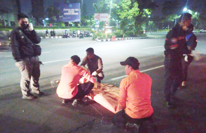 NAHAS: Petugas mengevakuasi jenazah korban di Jalan Ahmad Yani, Surabaya. (ISTIMEWA)