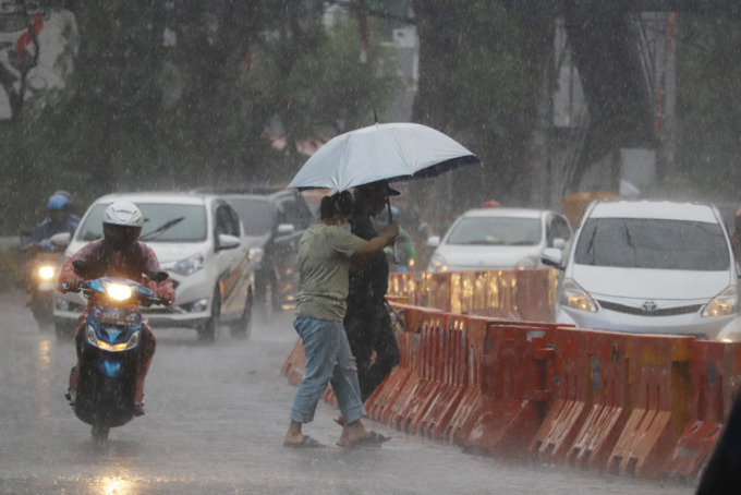 TRANSISI: Cuaca di Surabaya Jumat (31/3) diguyur hujan dari siang hingga malam hari. Salah satu warga melintas di kawasan kompleks Balai Pemuda ditengah guyuran hujan. (Rahmat Sudrajat/Radar Surabaya)
