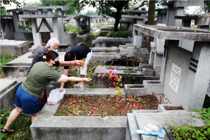 PEMBERSIHAN MAKAM: Salah satu keluarga Tionghoa melakukan tradisi Cheng Beng di makam keluarganya di Pemakaman Kristen Kembang Kuning, Rabu (5/4). (ANDY SATRIA/RADAR SURABAYA)