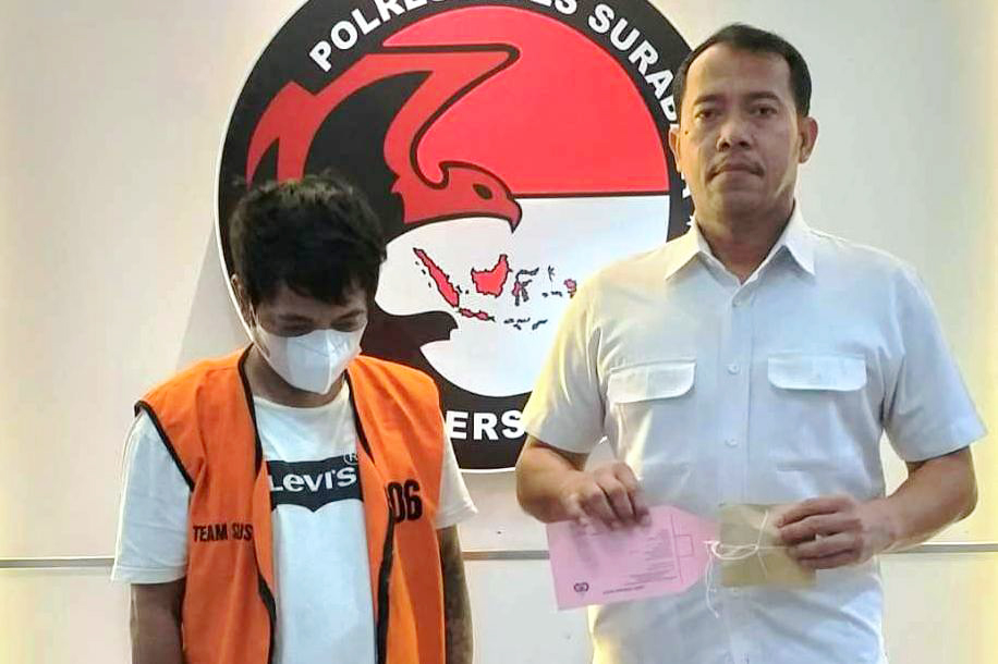 NYAMBI: Tersangka AK diamankan bersama barang bukti di Polrestabes Surabaya. (ISTIMEWA)