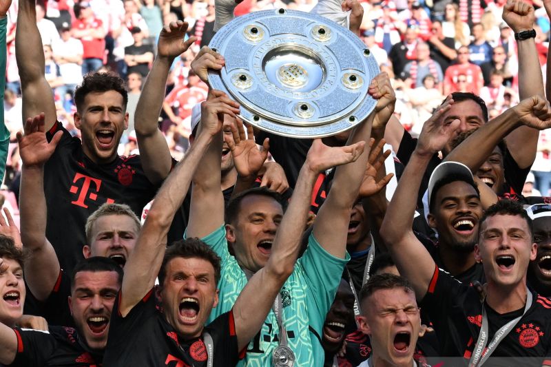 Para pemain Bayern Munich berselebrasi bersama trofi juara Liga Jerman usai pertandingan melawan FC Cologne 27 Mei 2023. (AFP/CHRISTOF STACHE)