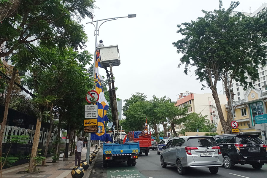 Petugas memasang umbu-umbul untuk memeriahkan HJKS ke-730 di Jalan Pemuda Surabaya, Kamis (11/5). (SURYANTO/RADAR SURABAYA)