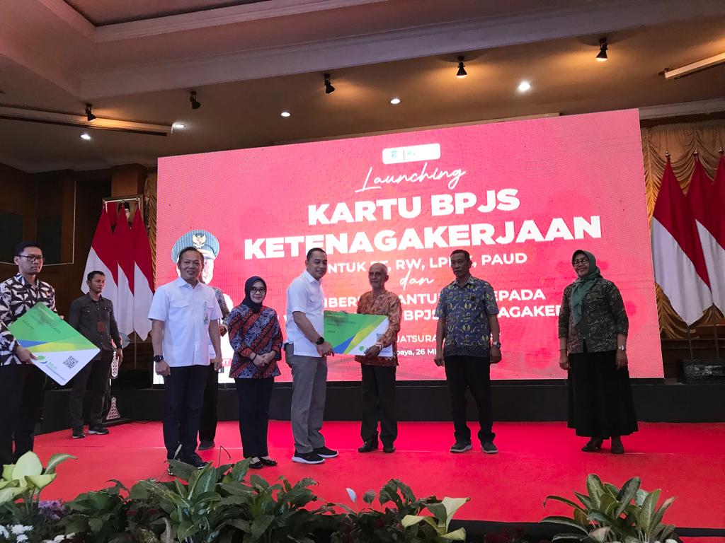 PENYERAHAN: Wali Kota Surabaya, Eri Cahyadi didampingi oleh Kepala Kantor Wilayah BPJS Ketenagakerjaan Jatim, Hadi Purnomo saat menyerahkan simbolis kartu kepesertaan bagi RT, RW, LPMK, dan PAUD, Jumat (26/5). (Nurul Afiah/Radar Surabaya)