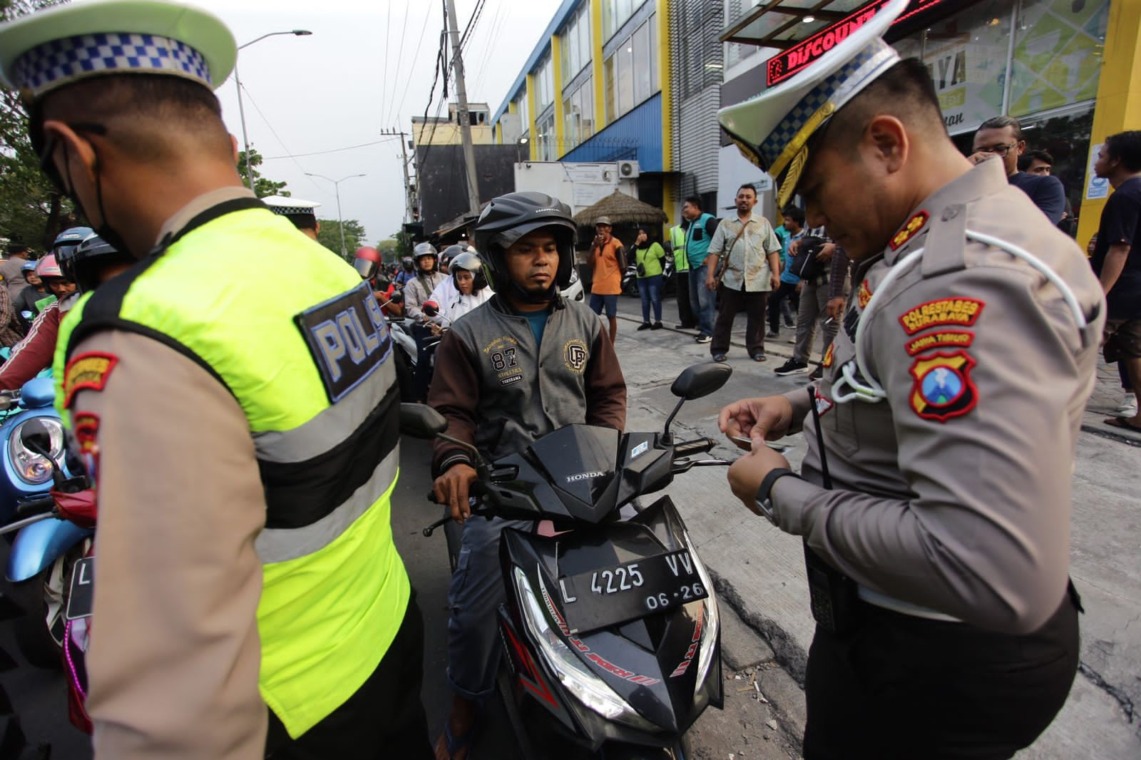 BIAR TERTIB : Polisi melakukan tilang manual di salah satu ruas jalan di Surabaya. (ISTIMEWA)