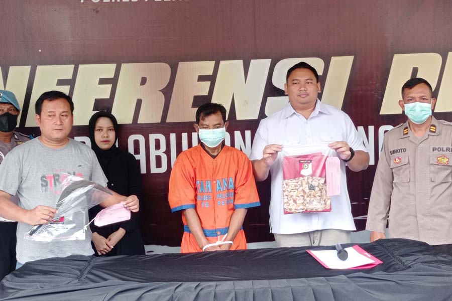 RESIDIVIS: Tersangka AR diamankan di Polres Pelabuhan Tanjung Perak Surabaya beserta barang bukti celurit sepanjang 57 cm, Selasa ((9/5). (SURYANTO/RADAR SURABAYA)