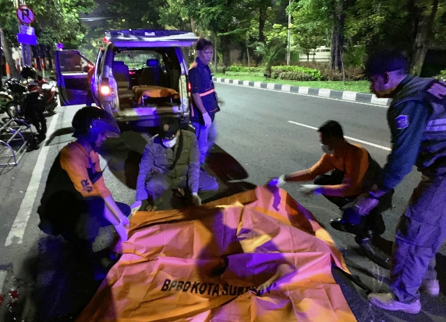 TRAGIS: Petugas mengevakuasi jenazah Devano Putra Hartanto di Jalan HR Muhammad, Surabaya. (ISTIMEWA)