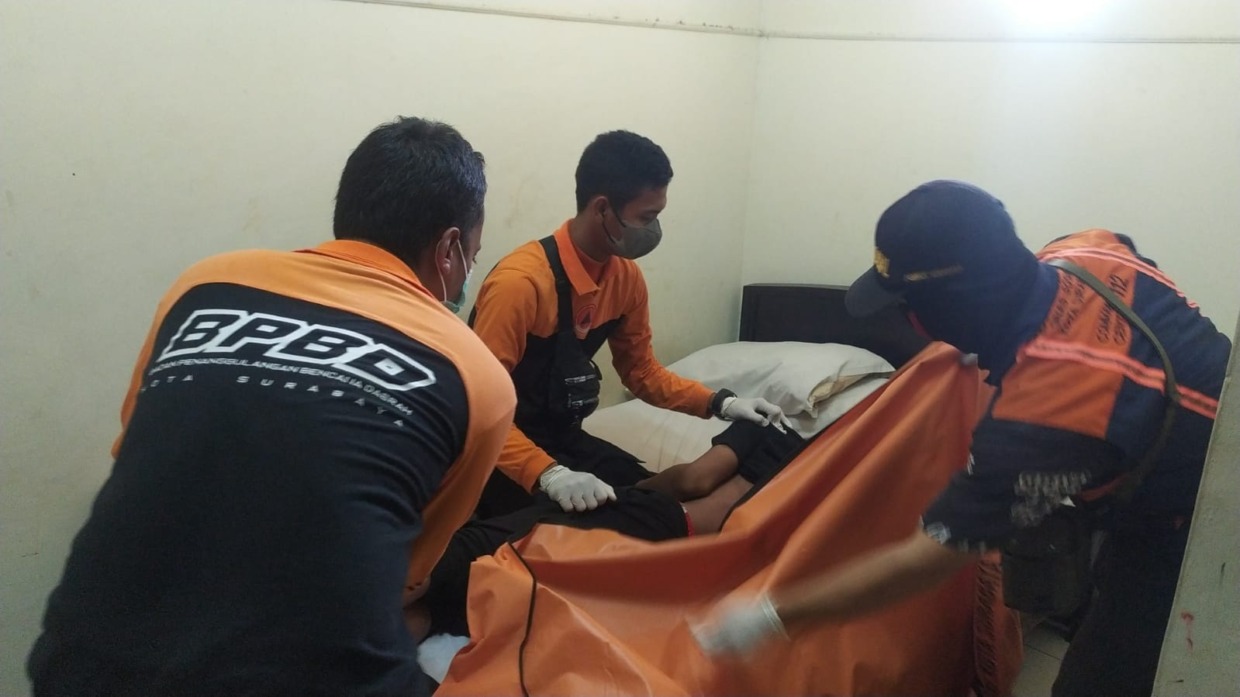 EVAKUASI: Petugas mengevakuasi jenazah Nursyaid Fahrur di Jalan Peneleh. (IST)