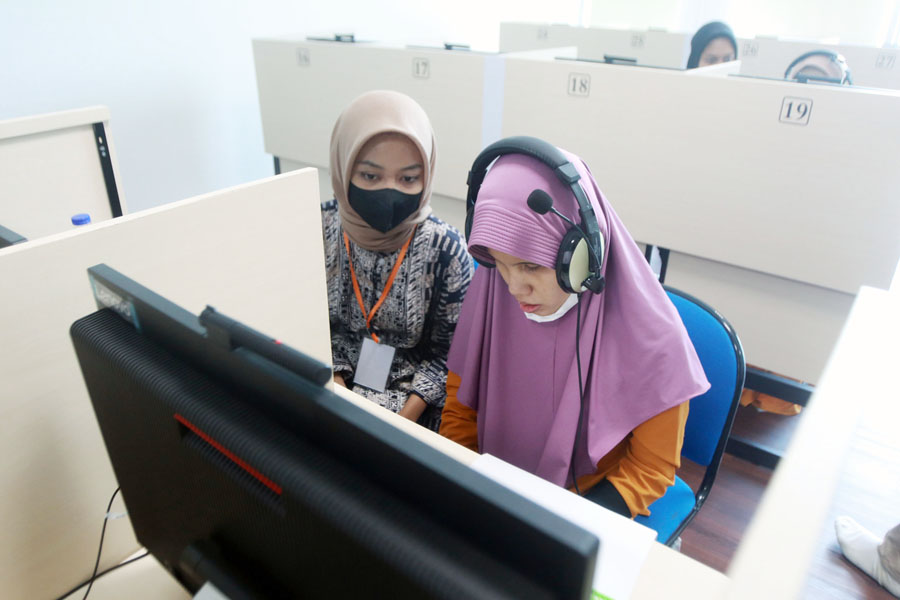 SESI KHUSUS: Penyandang tuna netra mengerjakan soal tes UTBK dengan ditemani pendampingnya di gedung Rektorat Universitas Negeri Surabaya, Rabu (10/5). (ANDY SATRIA/RADAR SURABAYA)