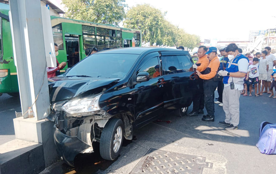 LAKA TUNGGAL: Petugas memeriksa TKP kecelakaan tunggal mobil tabrak tiang JPO di Jalan Wonokromo, Minggu (11/6). (MAHRUS/RADAR SURABAYA)