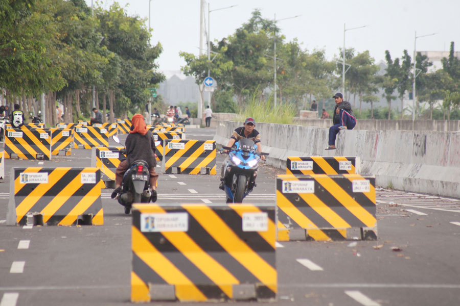SOLUSI MACET: Pengendara kendaraan bermotor melintas di Jalan Lingkar Luar Timur (JLLT) di kawasan Tambak Wedi Surabaya. (SURYANTO/RADAR SURABAYA)