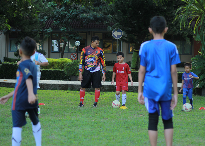 SERIUS: Suparno mengamati anak didiknya saat berlatih sepak bola di lapangan Pemkab Kediri Kamis (22/6). Mantan bek Persedikab ini berbagi ilmu kepada anak-anak PNS di Pemkab Kediri.