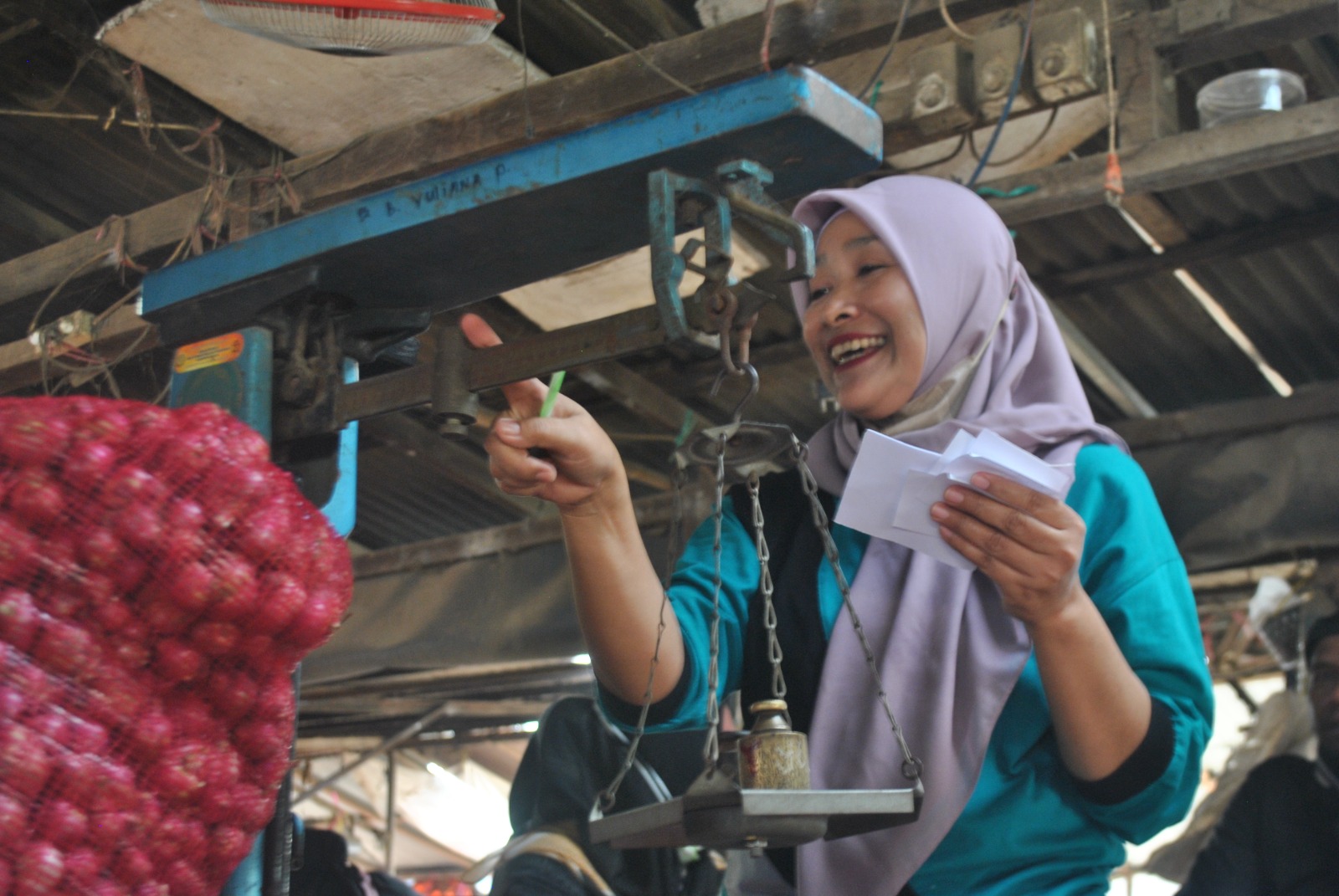 TERSENYUM: Pedagang menimbang brambang di Pasar Sukomoro. Sehari bisa jual 30 ton.