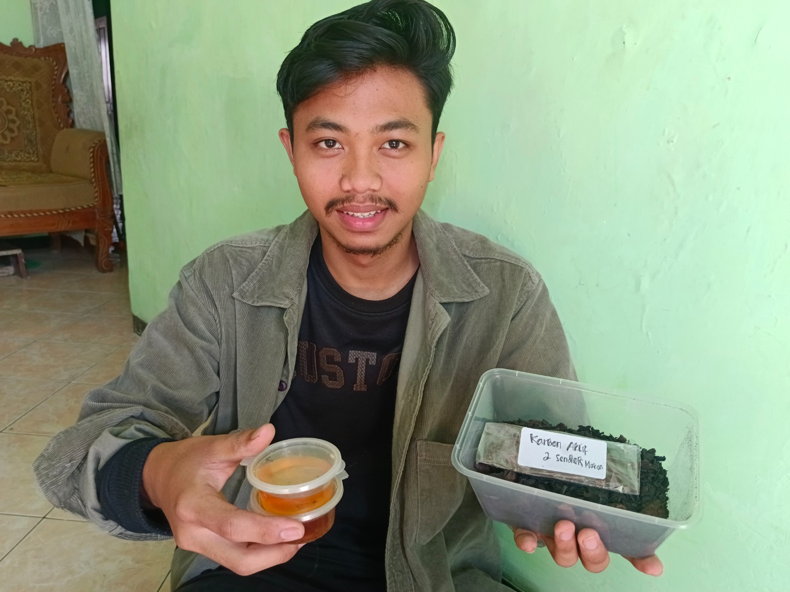 INOVATIF: Ramadhita Putra Purnomo menunjukkan minyak jelantah setelah diolah di rumah inovasi teknologi (Rumitek). Minyak jelantah menjadi jernih kembali.