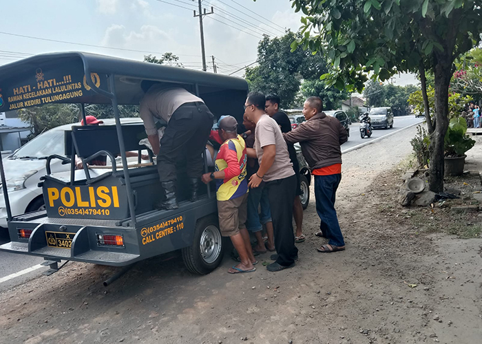 NAHAS: Petugas kepolisian dibantu warga membawa korban kecelakaan di Jalan Raya Kolak, Desa Wonorejo, Kecamatan Ngadiluwih, Minggu siang (25/6).