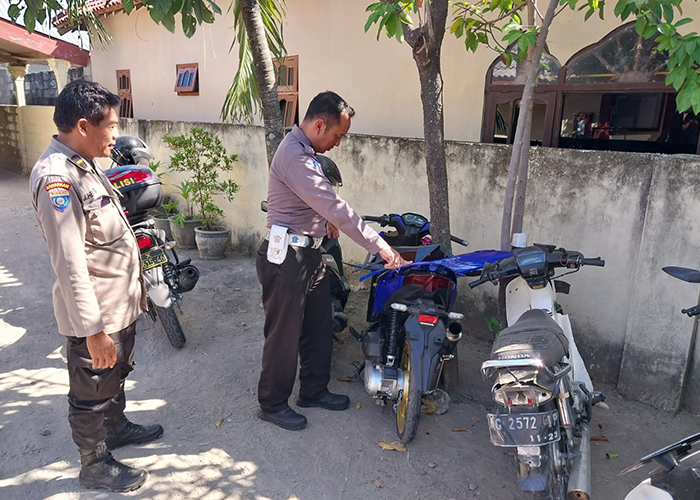 KURANG HATI-HATI: Petugas kepolisian memeriksa sepeda motor yang mengalami kecelakaan di simpang tiga jalan Dusun Bungkul, Desa Kapas, Kecamatan Kunjang kemarin.