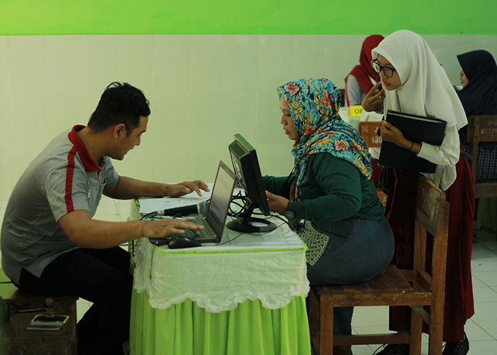 TUNGGU ZONASI: Siswa menyerahkan berkas saat PPDB tahap I. Senin (3/7) nanti lulusan SD di Kabupaten Kediri yang belum diterima bisa mendaftar kembali.