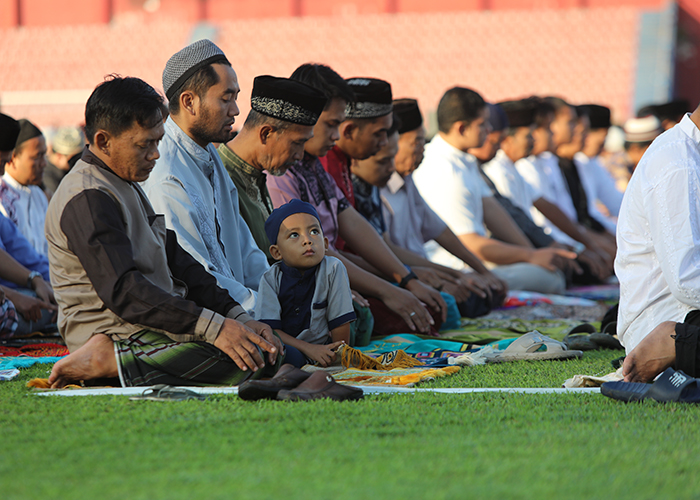 KHUSYUK: Ribuan jemaah mengikuti salat Id lebih awal di Stadion Brawijaya kemarin. Foto kanan, tim DKPP menunjukkan cacing pita di hati kambing dalam post mortem kemarin.