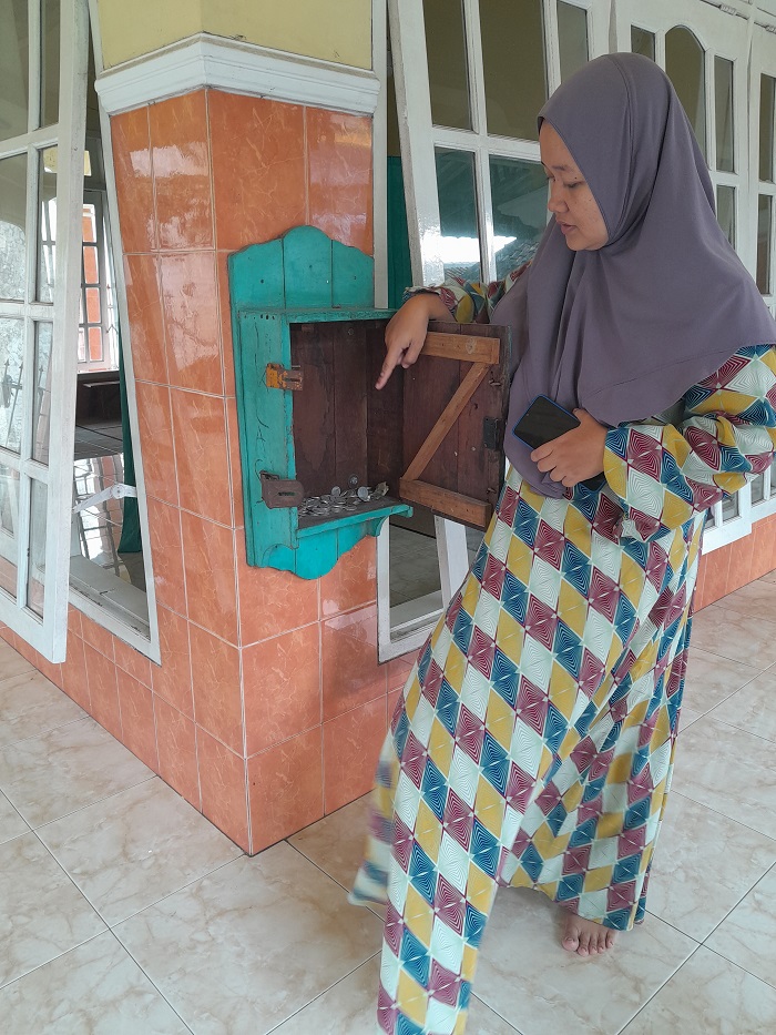 BUKTI KEJAHATAN: Alfi Hasanatin menunjukkan kotak amal yang dicongkel obeng di Musala Al Karomah, Jalan Sersan Suharmaji, Kelurahan Manisrenggo, Kecamatan Kota Kediri kemarin.