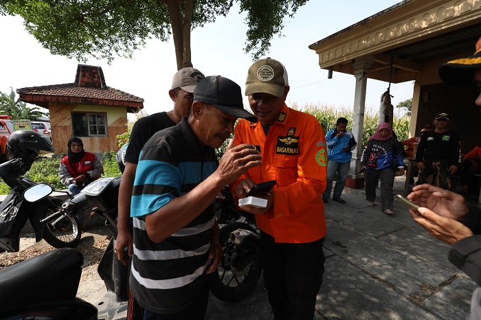 IDENTIFIKASI: Eko Aprianto menunjukkan foto penemuan jasad anak tenggelam yang ditemukan di Dusun Garurejo, Desa Gongseng, Kecamatan Megaluh, Jombang pada kakek Raffahel Ardianto kemarin.